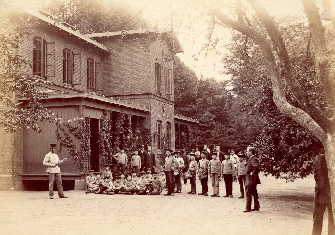 Kinder und Jugendliche mit Erziehern vor dem Haus